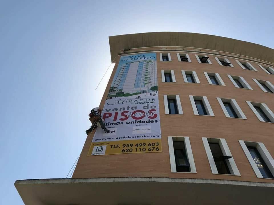 Lona de gran tamaño colgada en la fachada de un edificio