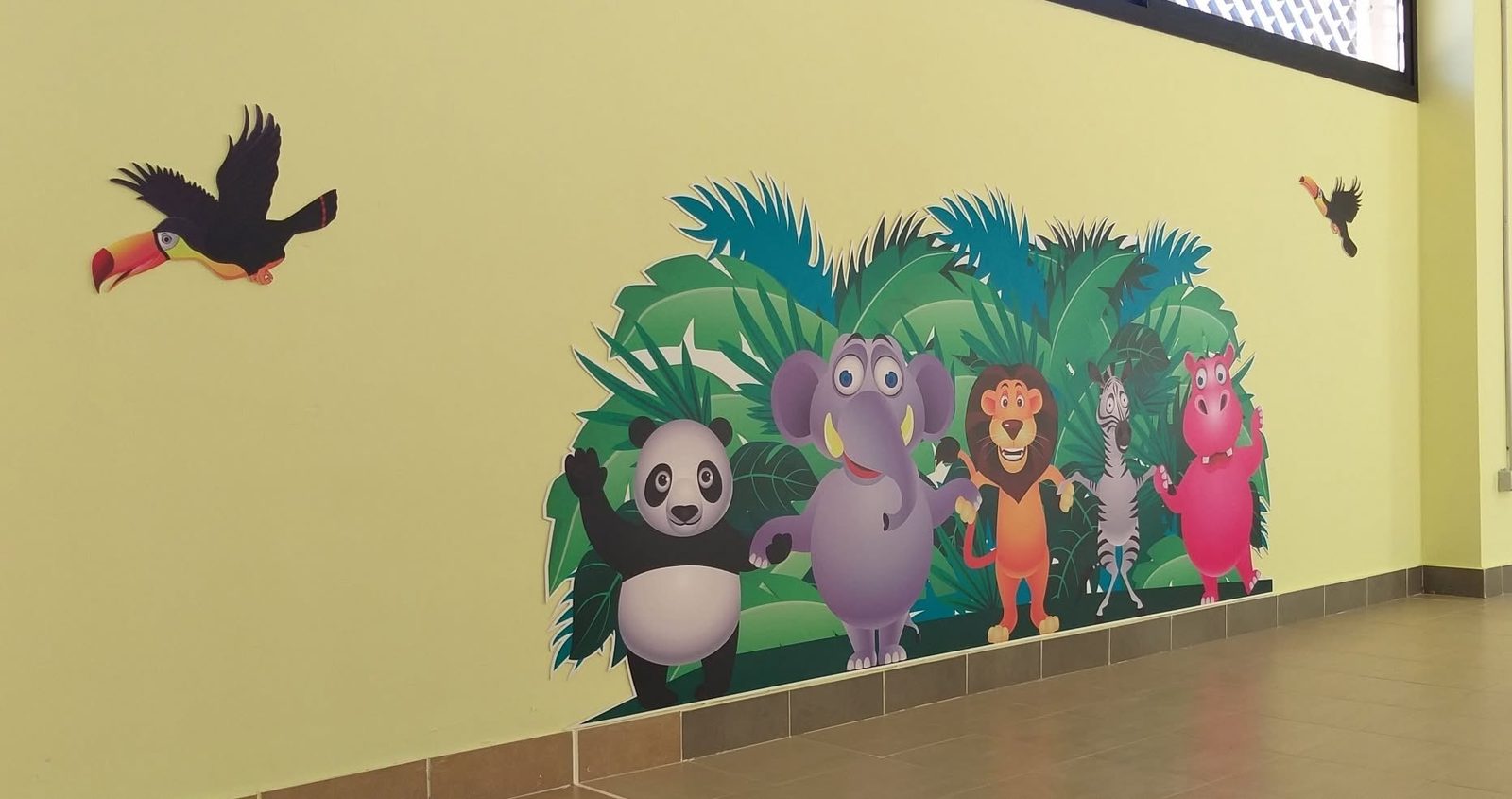 Mural de animales de la selva en una pared amarilla
