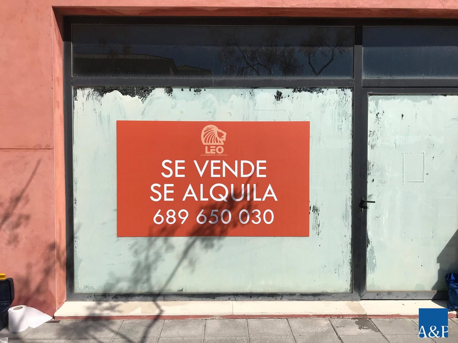 Cartel naranja de se vende y se alquila en el escaparate de un local