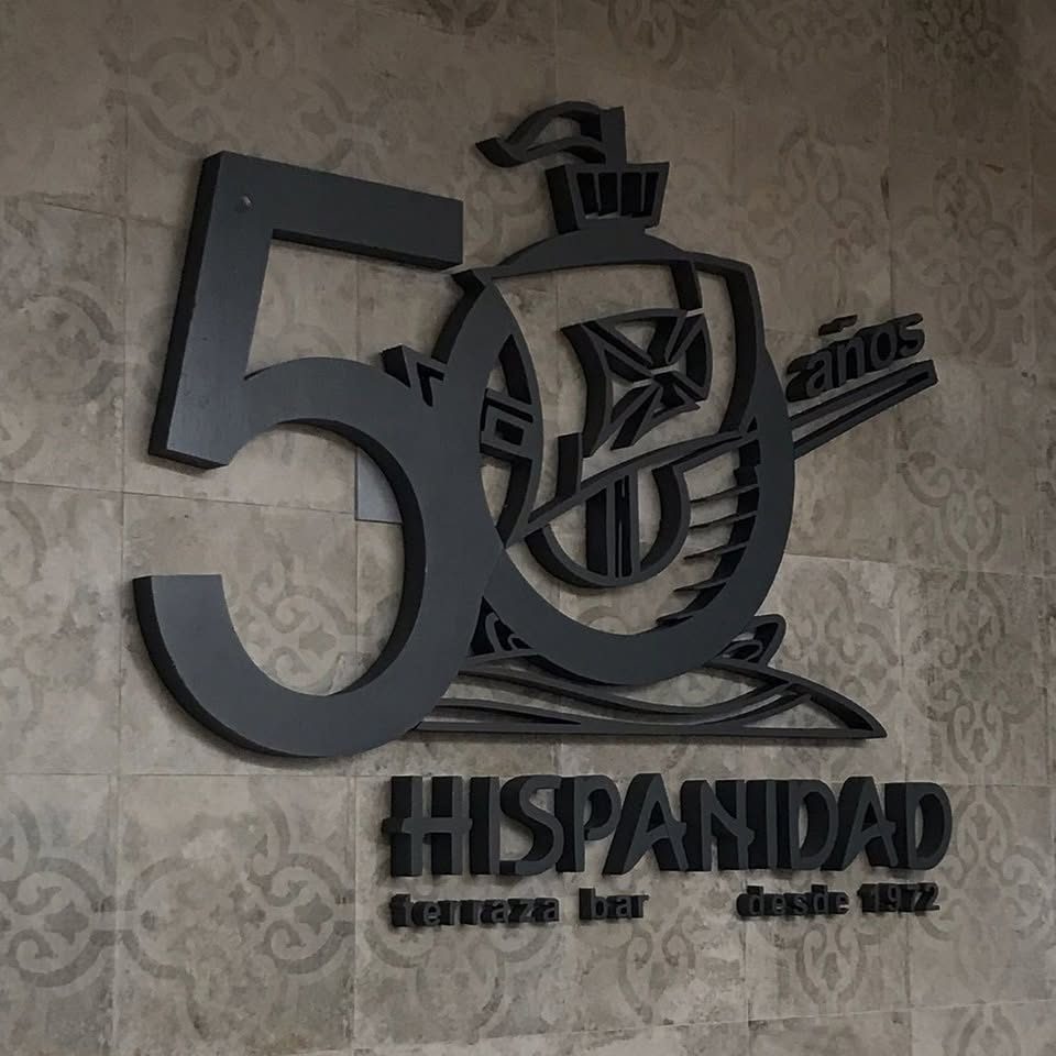 Número 50 y escudo en relieve negro sobre una pared