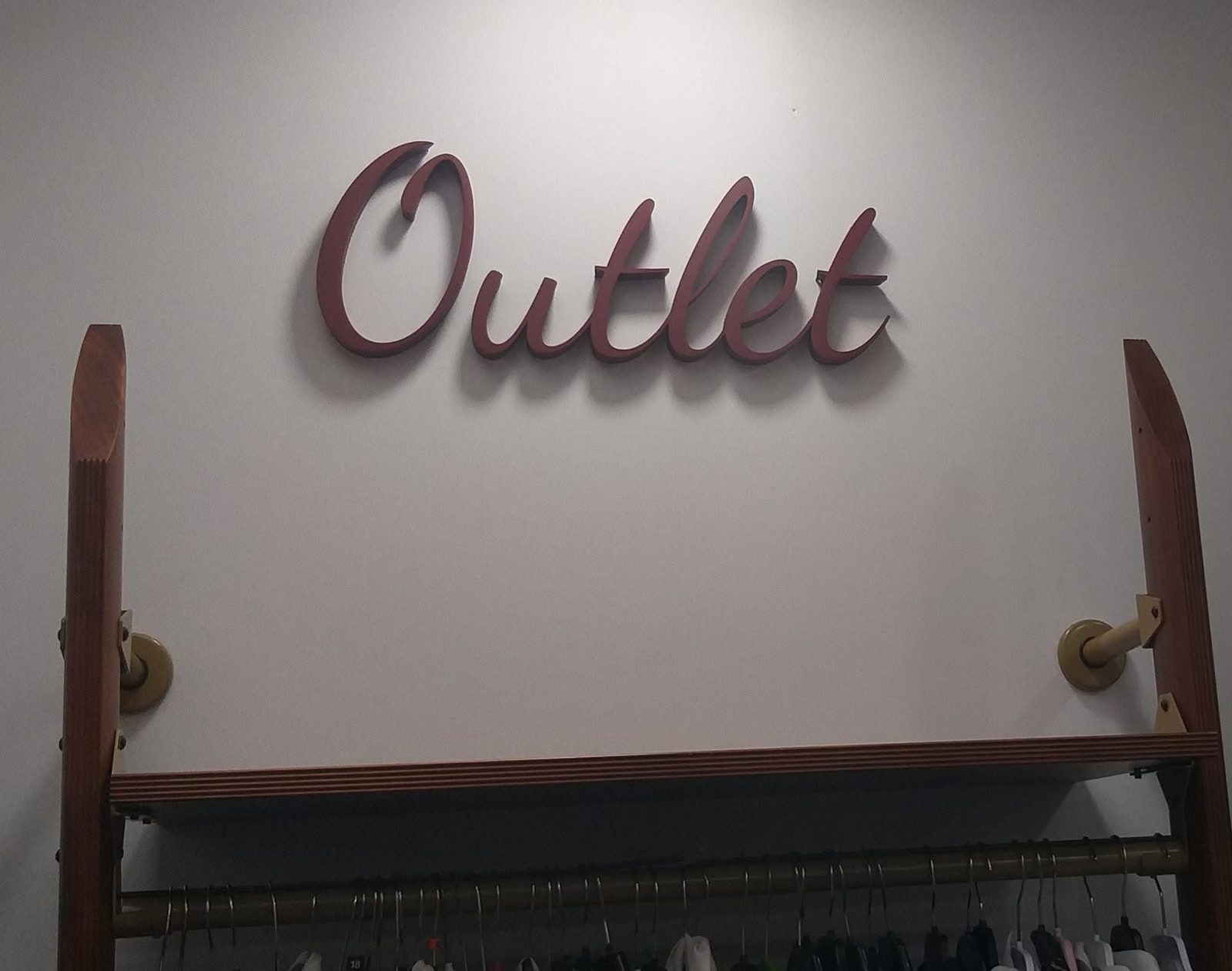 Palabra Outlet en letras de relieve sobre una pared blanca