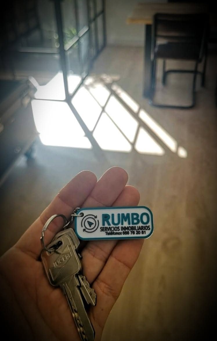 Mano sujetando una llave con un llavero personalizado