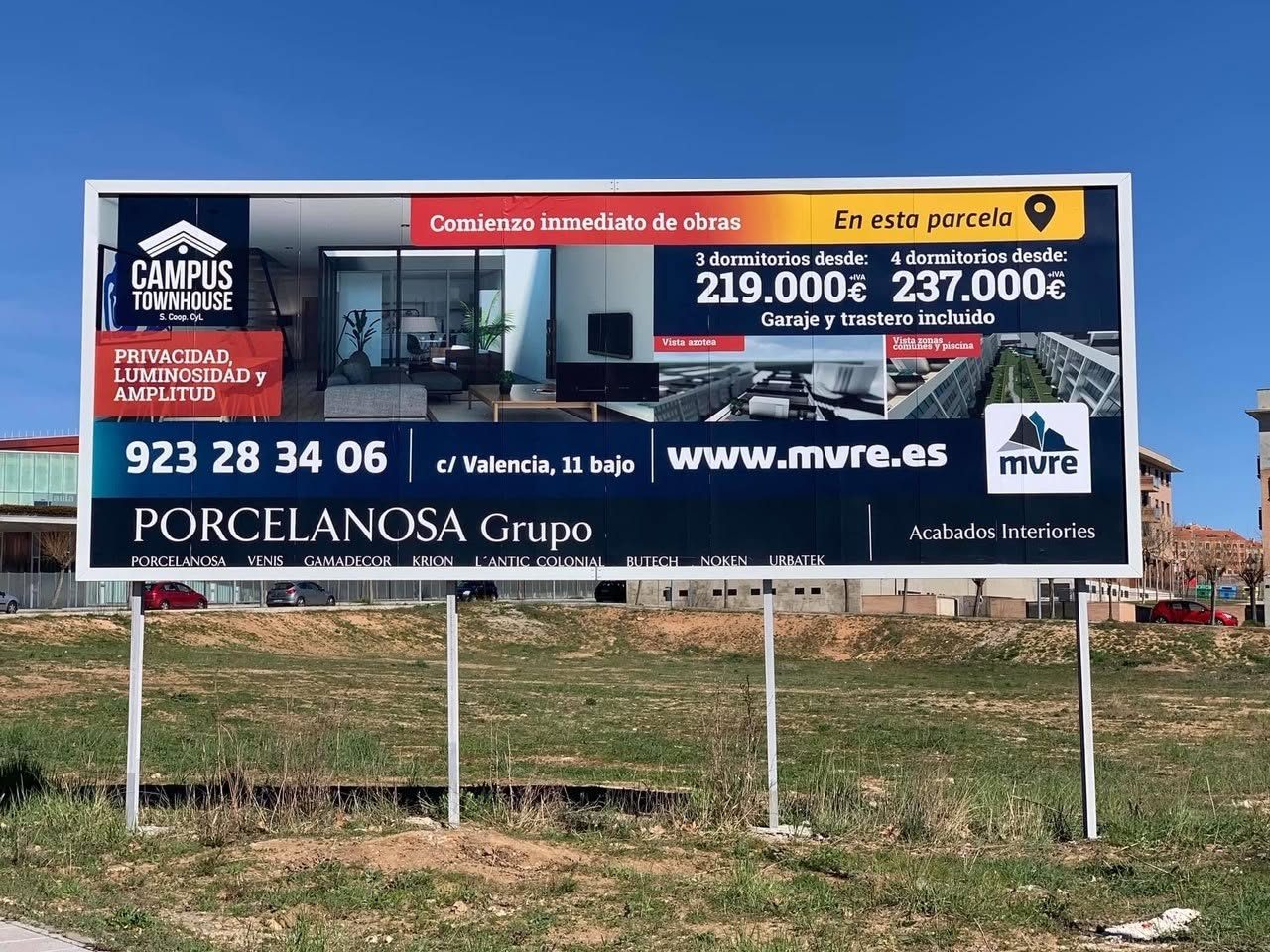 Valla publicitaria en un solar con anuncio de viviendas